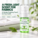 Fabric fragrance spray with a fresh light scent for clothing, featuring green botanical accents and folded fabrics