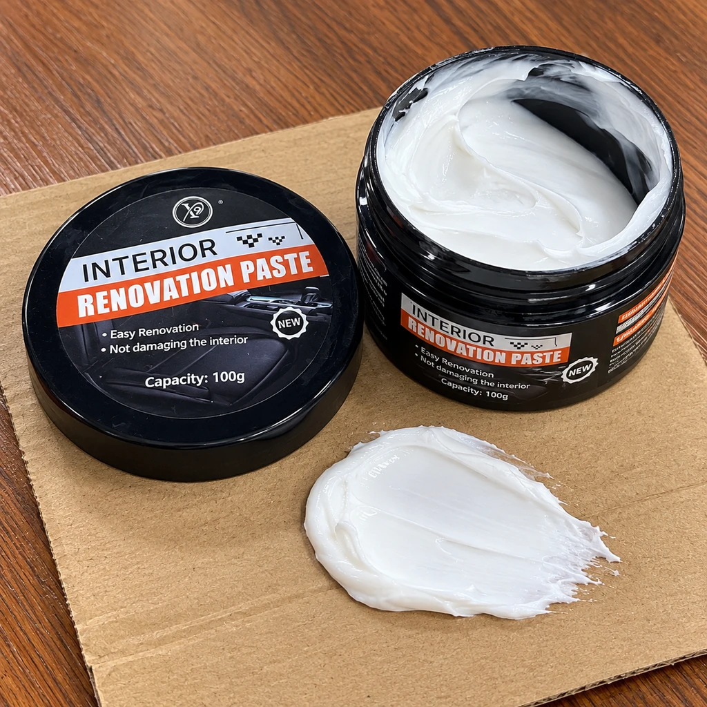 Open black jar of interior care paste with a white creamy sample and its lid on cardboard
